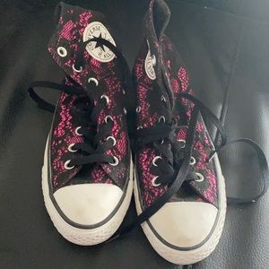Pink and black lace Converse sneakers.
